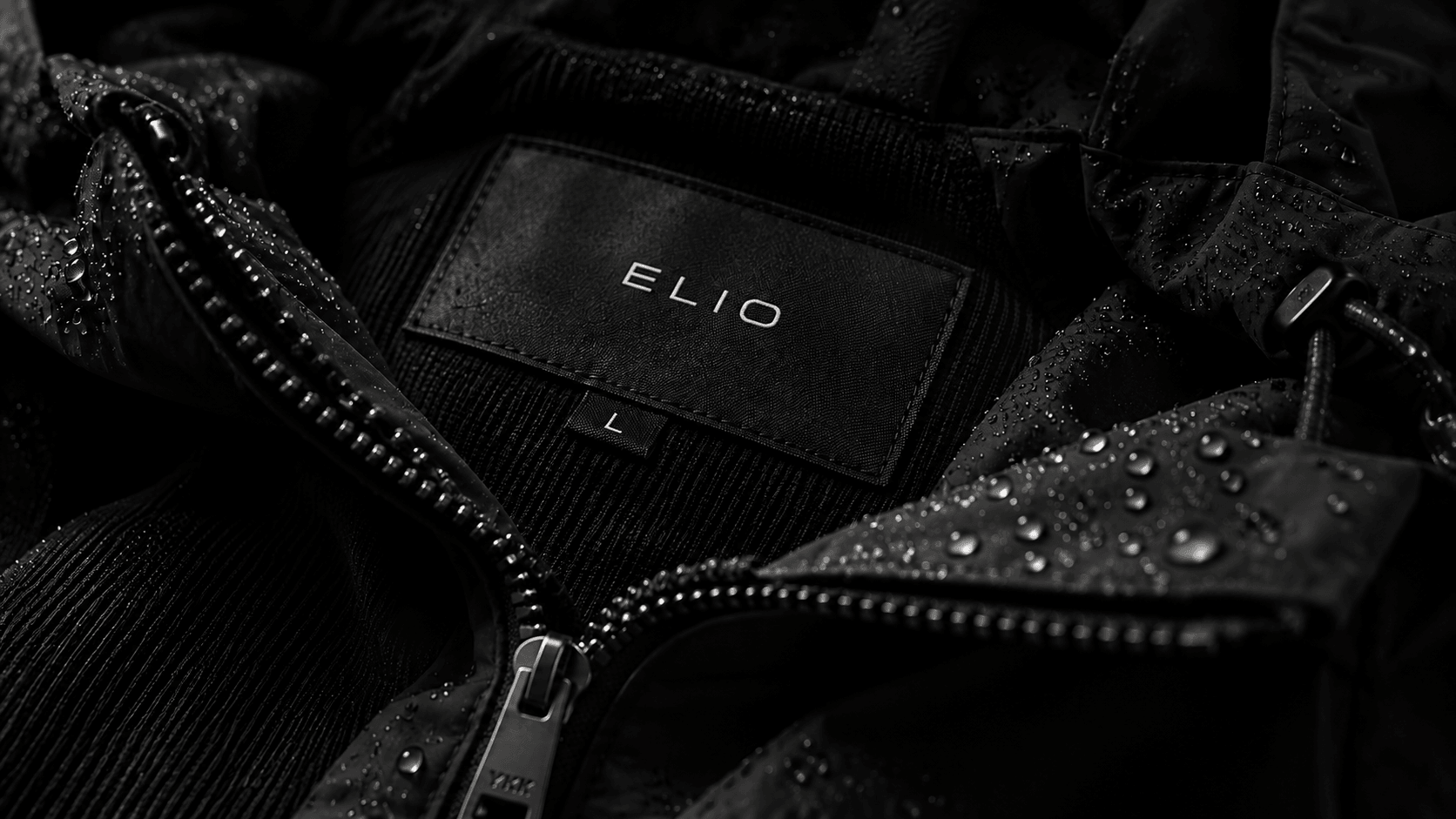 The Elio label inside a black shell beaded with rain