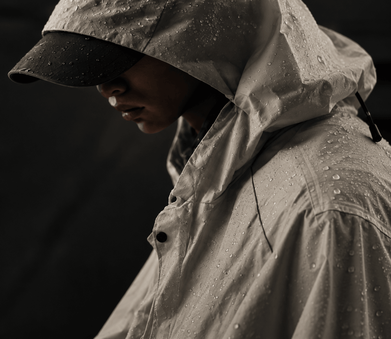 A hooded technical shell beaded with rain