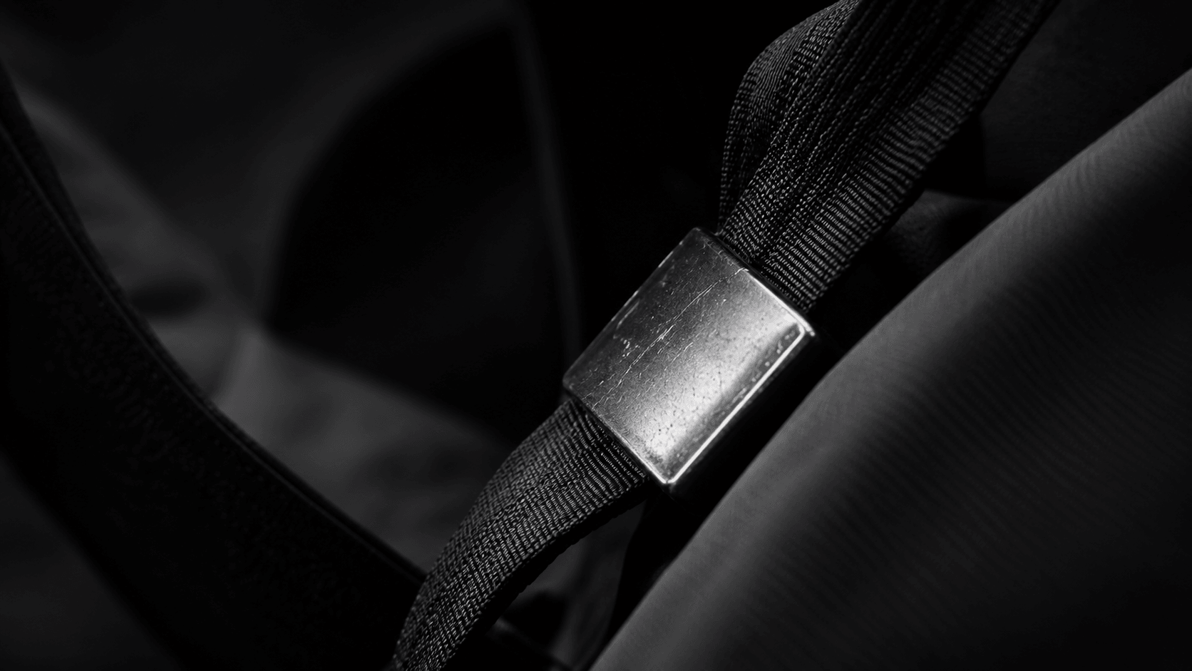 Close-up of black webbing and a metal strap slider