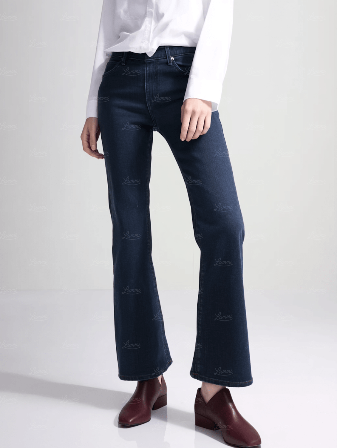 Dark flared jeans worn with a white shirt and ankle boots