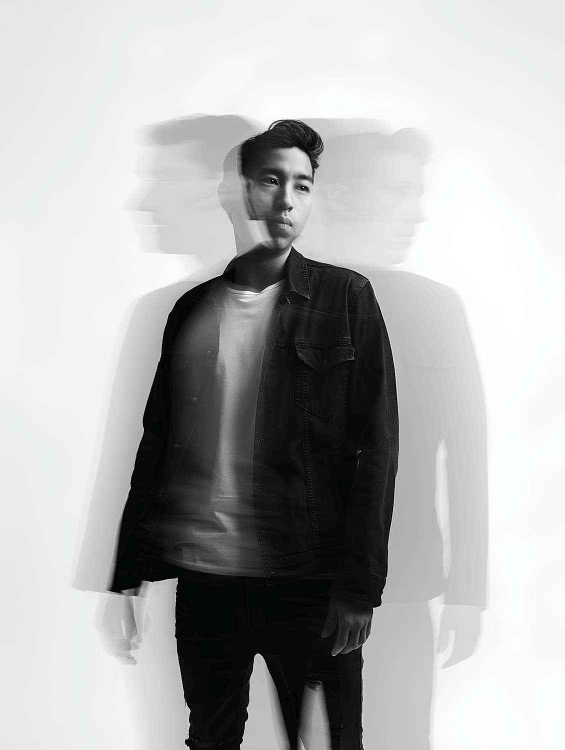 A man in a dark denim jacket over a white tee