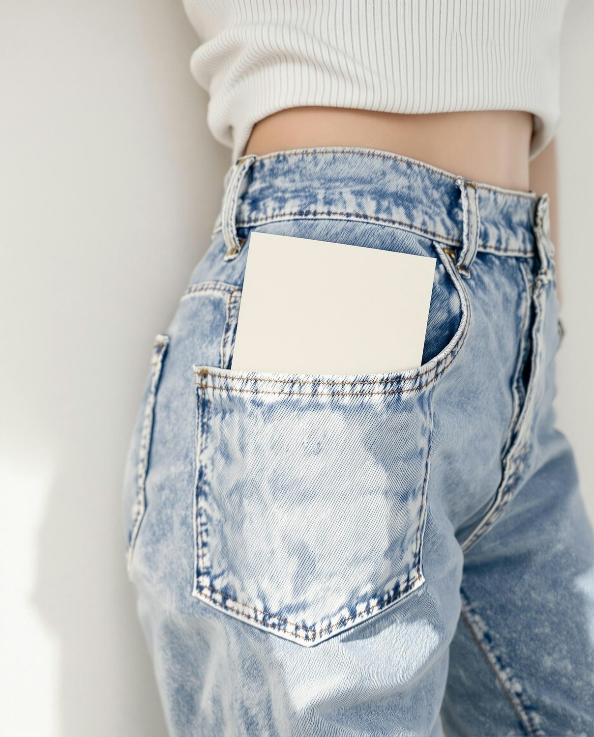 Close-up of the back pocket and waistband of washed jeans