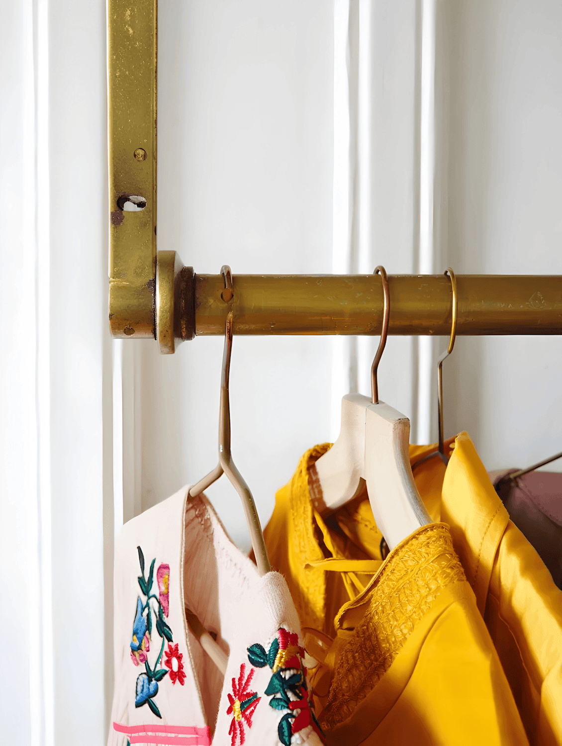 A styling rail of garments on wooden hangers